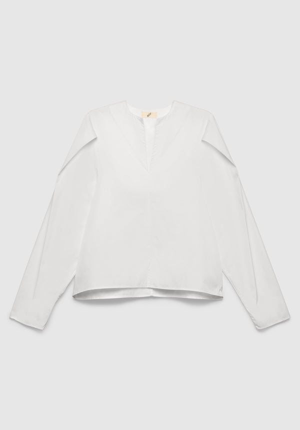 A white long-sleeve blouse with a relaxed fit, featuring a notch neckline and clean, minimal design, displayed against a plain background.

