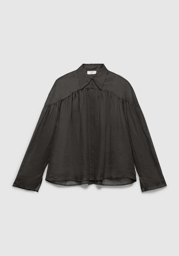 A dark gray long-sleeve blouse with a pointed collar and concealed button placket, featuring gathered detailing across the chest and shoulders for a loose, airy silhouette, displayed against a plain background.
