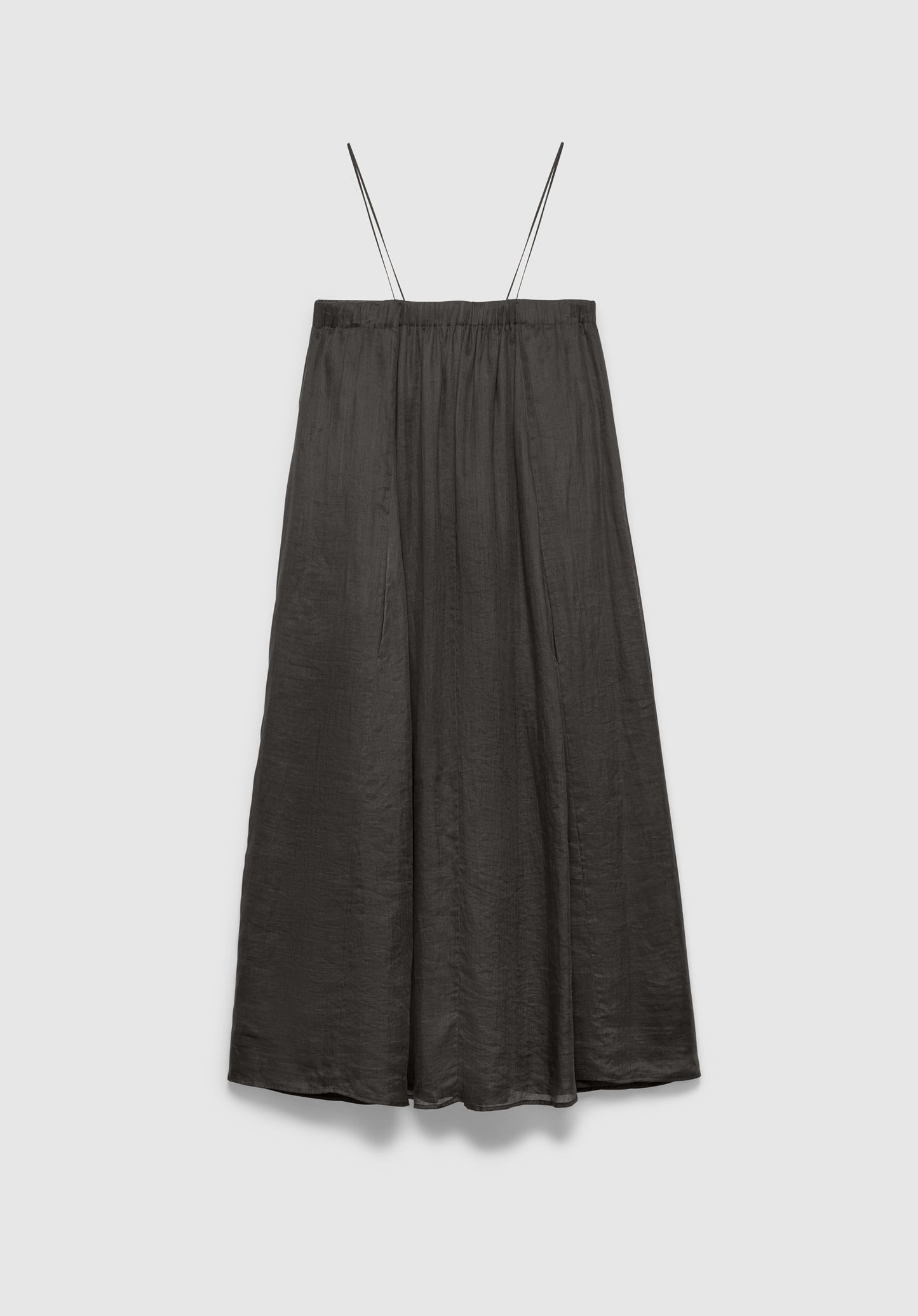 A dark gray midi skirt with a soft, flowy silhouette and a subtle textured finish, featuring thin shoulder straps and a gathered waistband, displayed against a plain background.
