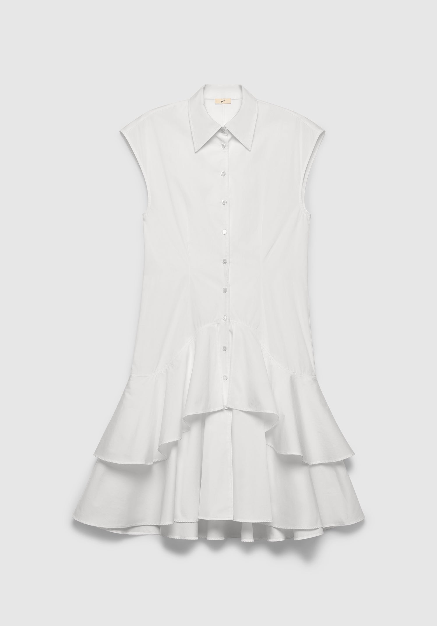 A white sleeveless shirt dress with a pointed collar and front button closure, featuring a fitted bodice and a tiered ruffled hem for a flared silhouette, displayed against a plain background.
