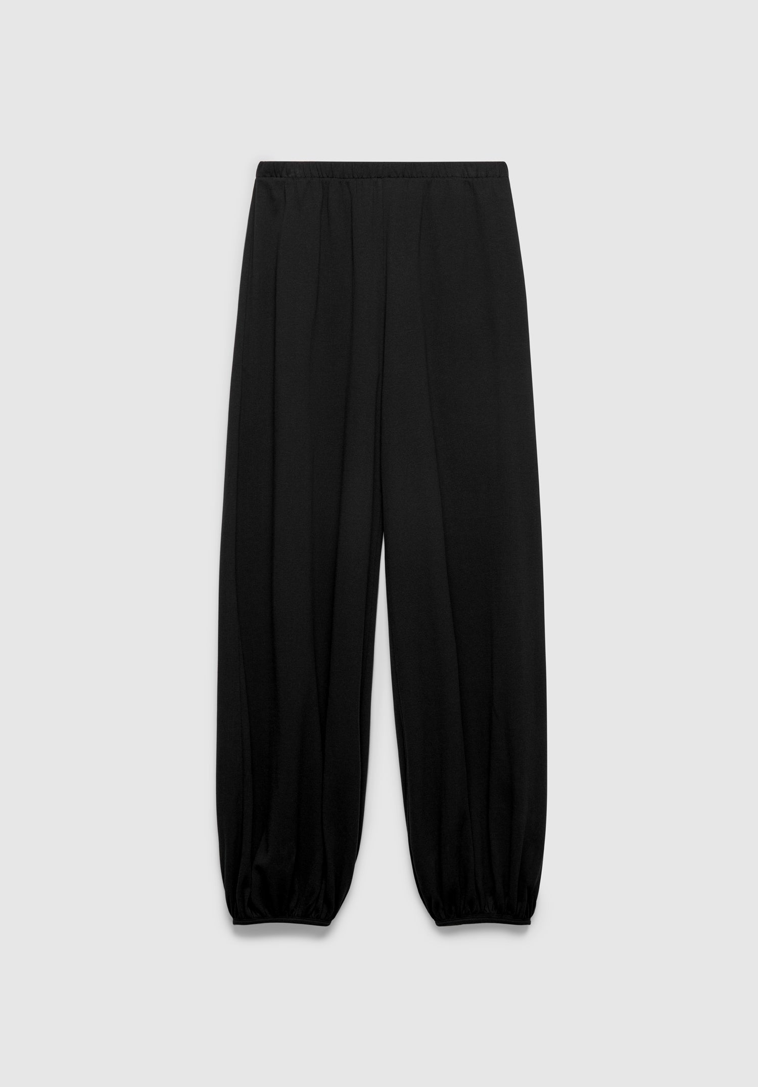 A pair of black relaxed-fit pants with an elastic waistband and gathered cuffs at the ankles, featuring a soft, draped silhouette, displayed against a plain background.
