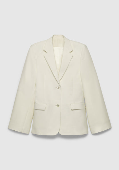 A cream-colored tailored blazer with a structured fit, featuring a notched lapel, two-button front closure, and flap pockets, displayed against a plain background.
